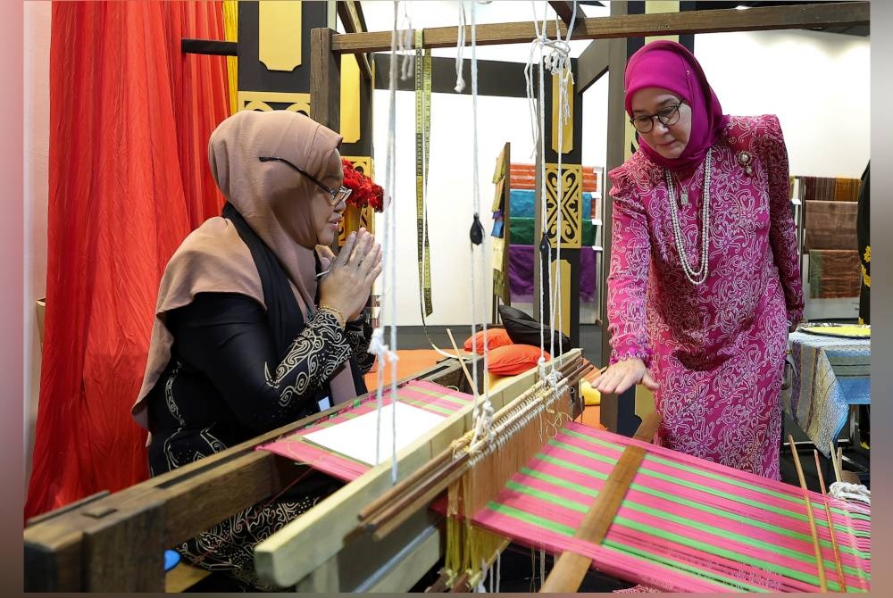 Raja Permaisuri Agong Tunku Azizah Aminah Maimunah Iskandariah berkenan melihat proses tenunan songket ketika berangkat ke CIMB Artober 2023 di Pusat Pameran dan Dagangan Antarabangsa Malaysia (MITEC) pada Khamis. - Foto Bernama.