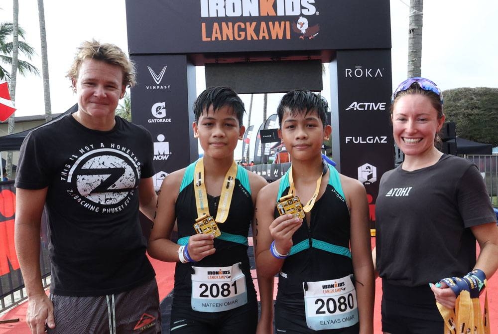 Elyaas Omar dan Mateen bergambar bersama atlet dari Australia Dimity-Lee Duke (kiri) dan Cassie Heaslip selepas berjaya menamatkan acara Ironkids sempena Kejohanan Ironman Malaysia dan Ironman Langkawi 70.3 pada Jumaat. - Foto Bernama