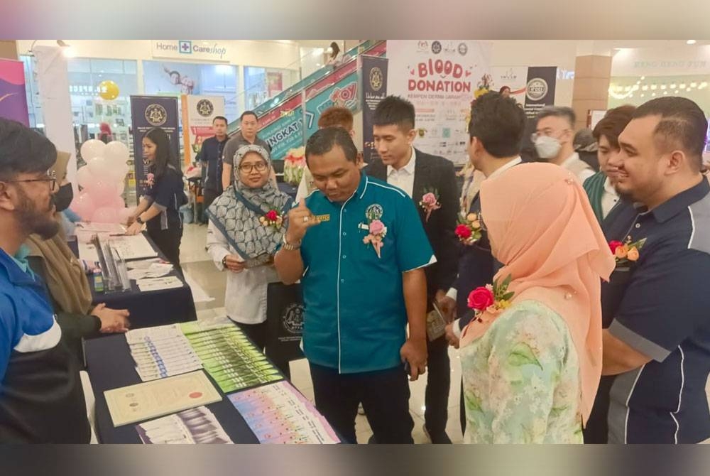 Noorman (tengah) bersama Enny Suhailis (depan) dan Masrudi (kanan, belakang) melawat pameran Perkeso Johor dalam Kempen Bazar Amal dan Kempen Derma Darah di Aeon Mall Kulaijaya pada Jumaat.