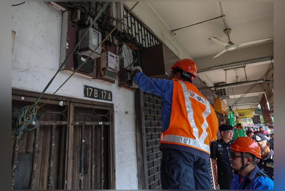 Petugas Tenaga Nasional Berhad (TNB) melakukan kerja-kerja pemotongan bekalan elektrik semasa Operasi Op Dadu di sekitar Jelapang, pada Jumaat. - Foto Bernama