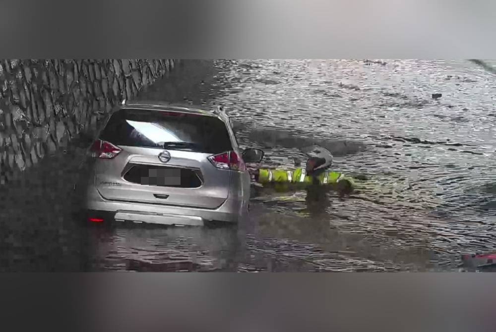 Anggota JSPT Kuala Lumpur menyelamatkan seorang pemandu selepas keretanya tenggelam dalam banjir di terowong Jalan Sow Lin, Kuala Lumpur pada Jumaat.