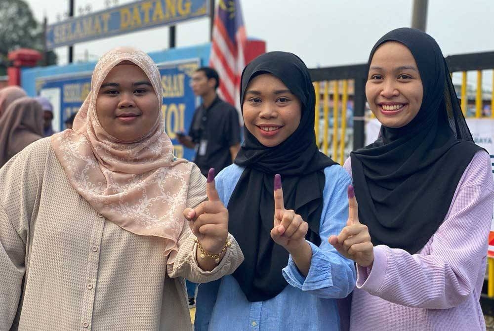 Dari kiri: Nurul Ain Najwa Amat Azahar, 20, Nur Ifa dan Norliana Ayuni Rafie, 21, selesai membuang undi di SMK Chemomoi sempena PRK DUN Pelangai.