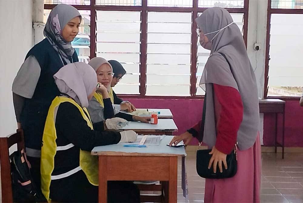 Nur Amira Farhana sedang bersedia untuk membuang undi di saluran tiga di Pusat Mengundi di SMK Seri Pelangai pada Sabtu.