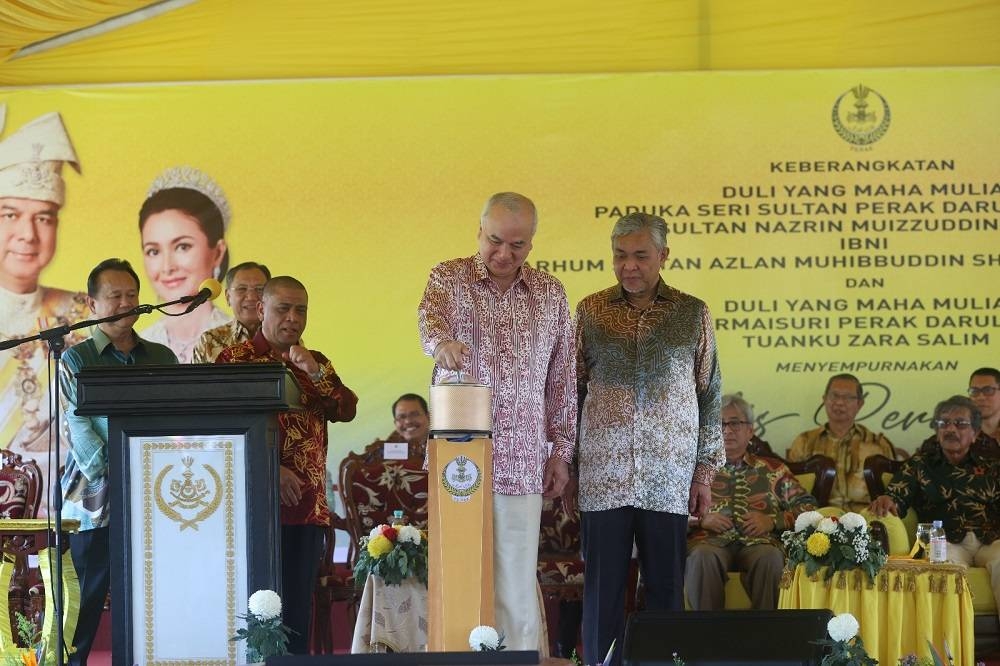 Sultan Nazrin (kiri) menyempurnakan gimik ketika Majlis Perasmian Jambatan Bagan Datuk pada Sabtu.