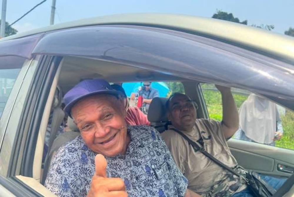 Zaffarul (kanan) bersama bapanya, Harmeni (kiri) hadir ke Pusat Mengundi SMK Seri Pelangai hari ini. - Foto Astro AWANI