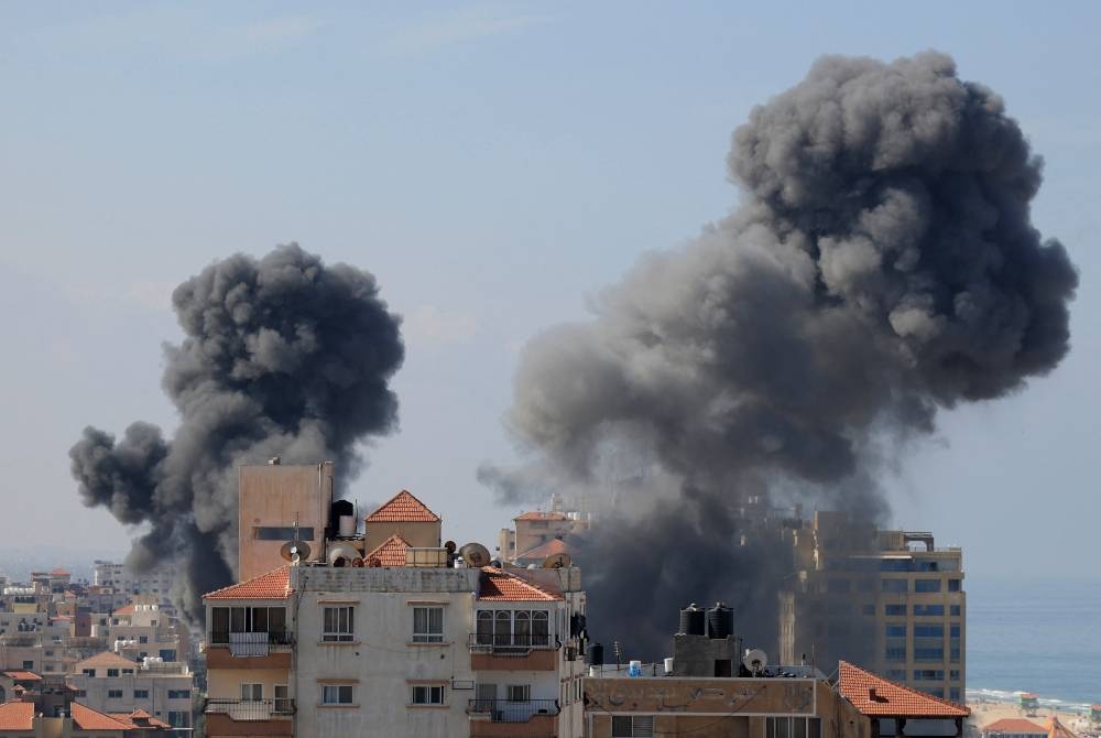 Asap tebal memenuhi ruang udara di kawasan penempatan di Gaza City selepas rejim Zionis melancarkan serangan balas pada Sabtu. - Foto AFP