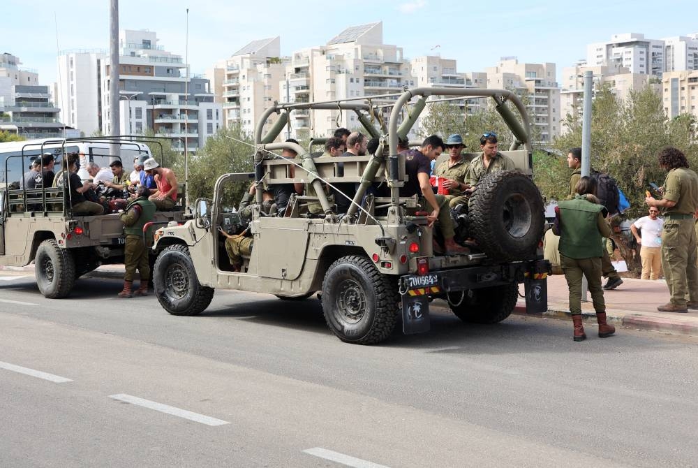 Pasukan tentera simpanan Israel dibawa menaiki jip menuju ke pangkalan di selatan Tel Aviv pada Sabtu. - Foto AFP