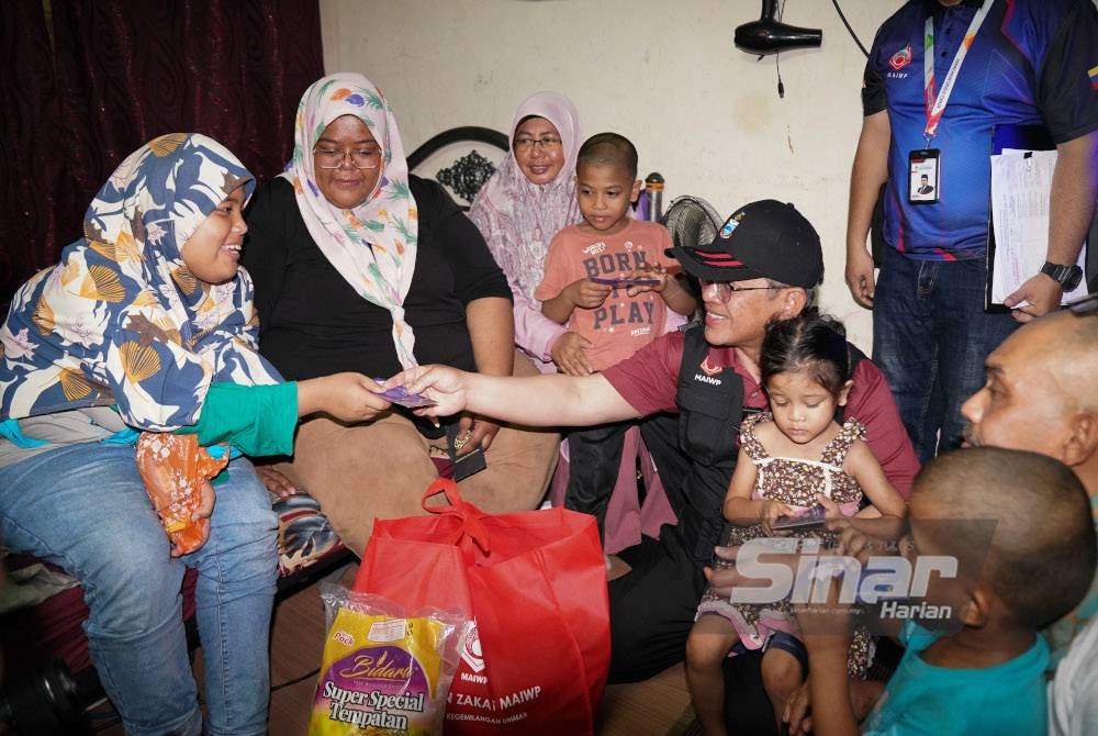 Mohd Na'im menyerahkan sumbangan kepada keluarga asnaf semasa Program Jejak Gelandangan MAIWP di Jalan Chow Kit, Kuala Lumpur pada Jumaat. - Foto Sinar Harian/ROSLI TALIB