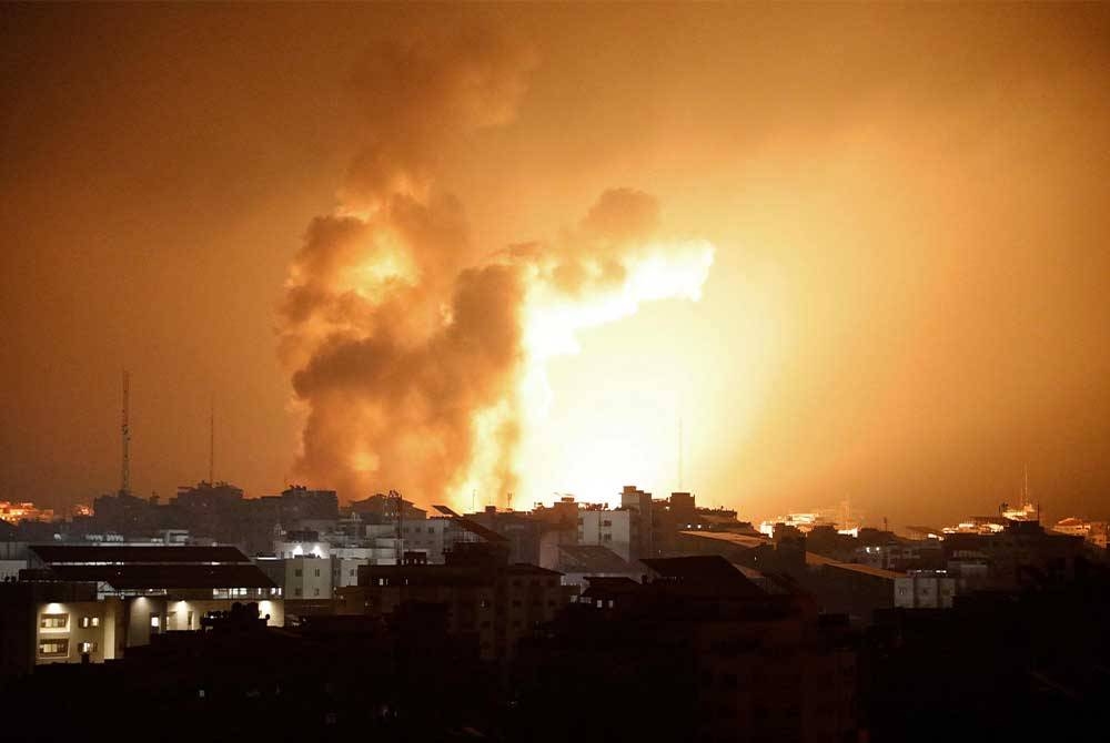 Api dan asap berkepul di atas bangunan semasa serangan udara Israel di Semenanjung Gaza. Foto AFP