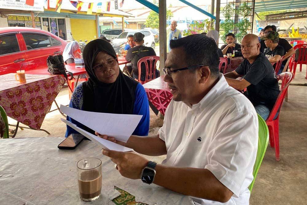 Amizar menerima surat permohonan bantuan ketika menyantuni pengundi dan minum pagi di Felda Chemomoi, pada Ahad.