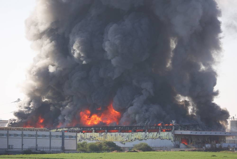 Sebuah gudang di bandar Gedera di wilayah Israel yang diduduki musnah dlaam kebakaran selepas terkena roket yang dilancarkan dari Gaza. - Foto: EPA