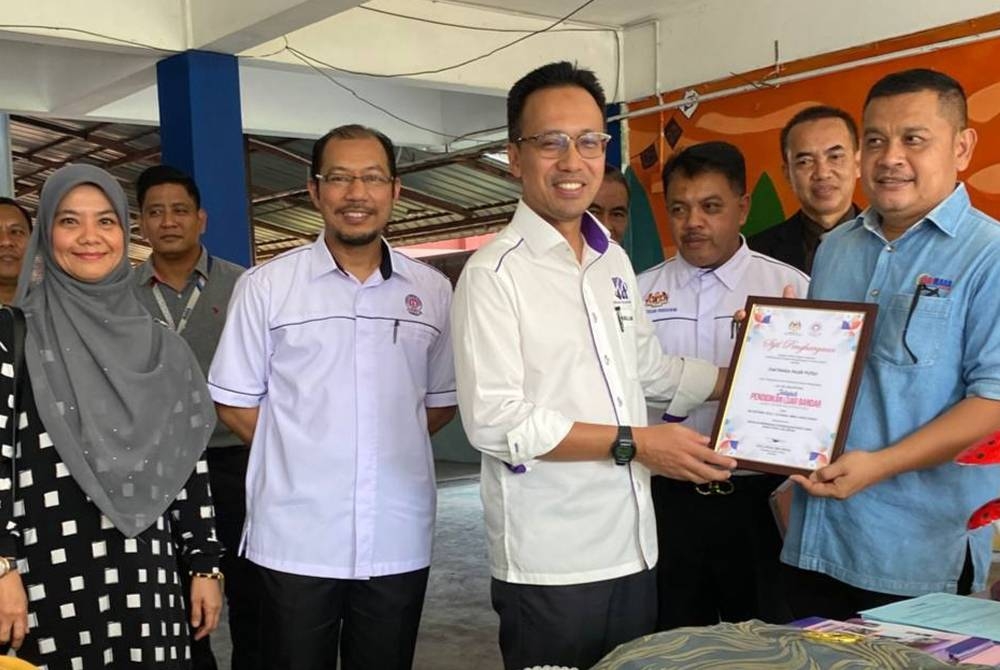 Fazli Rizal (dua dari kiri) bersama Faisalludin (tiga dari kiri) menyampaikan sijil penghargaan kepada pihak yang bekerjasama menjayakan Majlis Penutup Program Jelajah Pendidikan Luar Bandar Negeri Kelantan 2023 di SMK Bukit Jawa, Pasir Puteh.