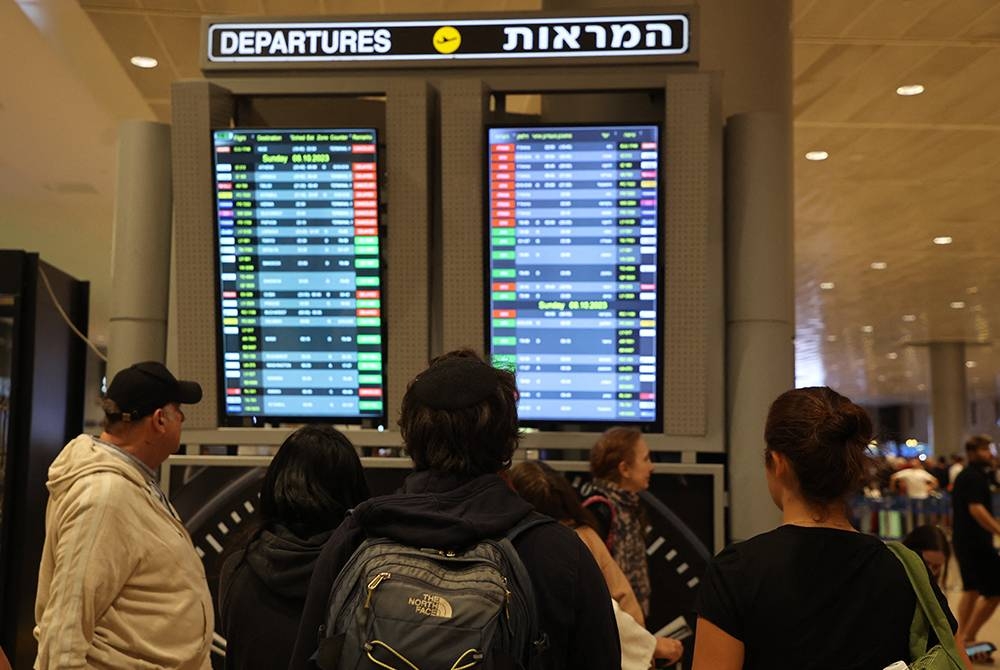 Penumpang melihat jadual penerbangan di Lapangan Terbang Ben Gurion, Tel Aviv selepas beberapa syarikat utama membatalkan perkhidmatan mereka buat sementara waktu. - Foto AFP