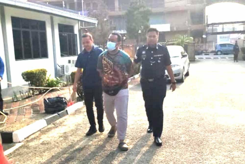 Mohd Bazrin (tengah) diiring polis sebaik tiba di Mahkamah Majistret Tampin pada Isnin.