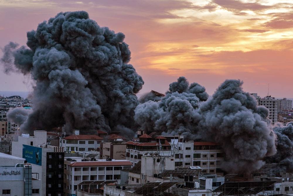 Asap memenuhi ruang udara selepas pesawat pejuang Israel menyasarkan menara Palestin di Kota Gaza. - Foto EPA