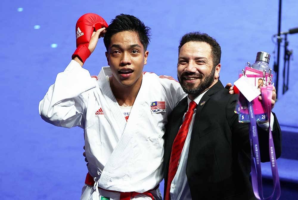 Arif Afifudin bersama jurulatihnya, Tamer Abdelraouf Mourssy (kanan) selepas meraih pingat emas Sukan Asia 2022 di Hangzhou pada Sabtu lalu.
FOTO: BERNAMA