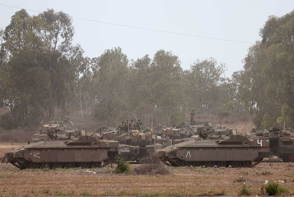 Unit kereta kebal Israel mengambil kedudukan di luar bandar Sderot berhampiran sempadan Gaza pada Isnin. - Foto AFP