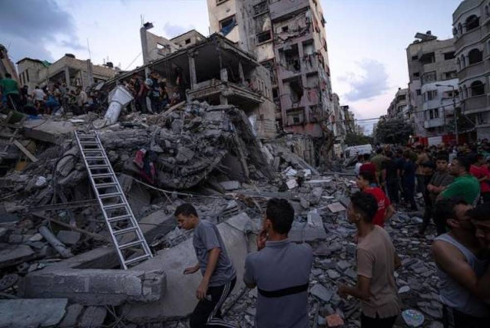 Orang ramai lakukan usaha mencari dan menyelamat mangsa di bawah runtuhan bangunan di Gaza. - Foto AP