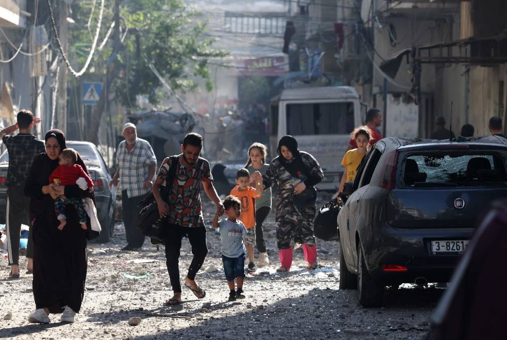 Penduduk Palestin mengosongkan kawasan kejiranan di Kota Gaza pada Rabu ketika pertempuran sengit antara Israel dan gerakan Hamas berterusan untuk hari kelima berturut-turut. - Foto AFP