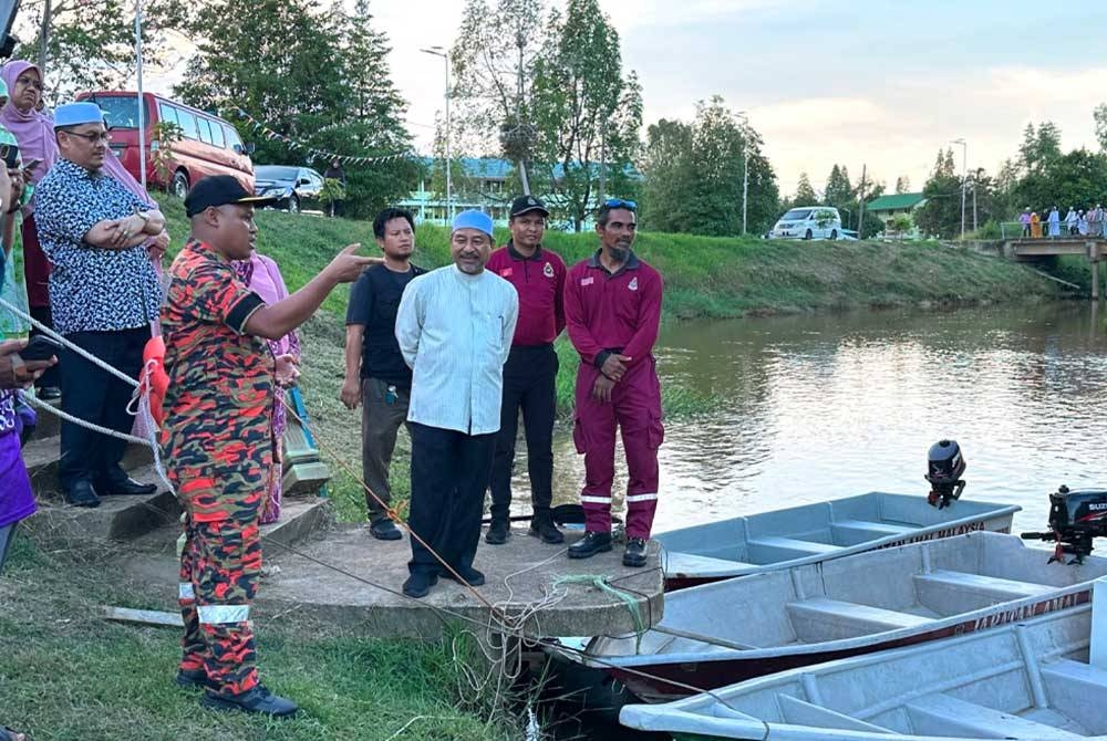 Mohd Nassuruddin (tengah) mendengar penerangan daripada seorang pegawai bomba semasa Latihan Kesiapsiagaan Sukarelawan Menghadapi Bencana 2023 di Meranti di Pasir Mas.