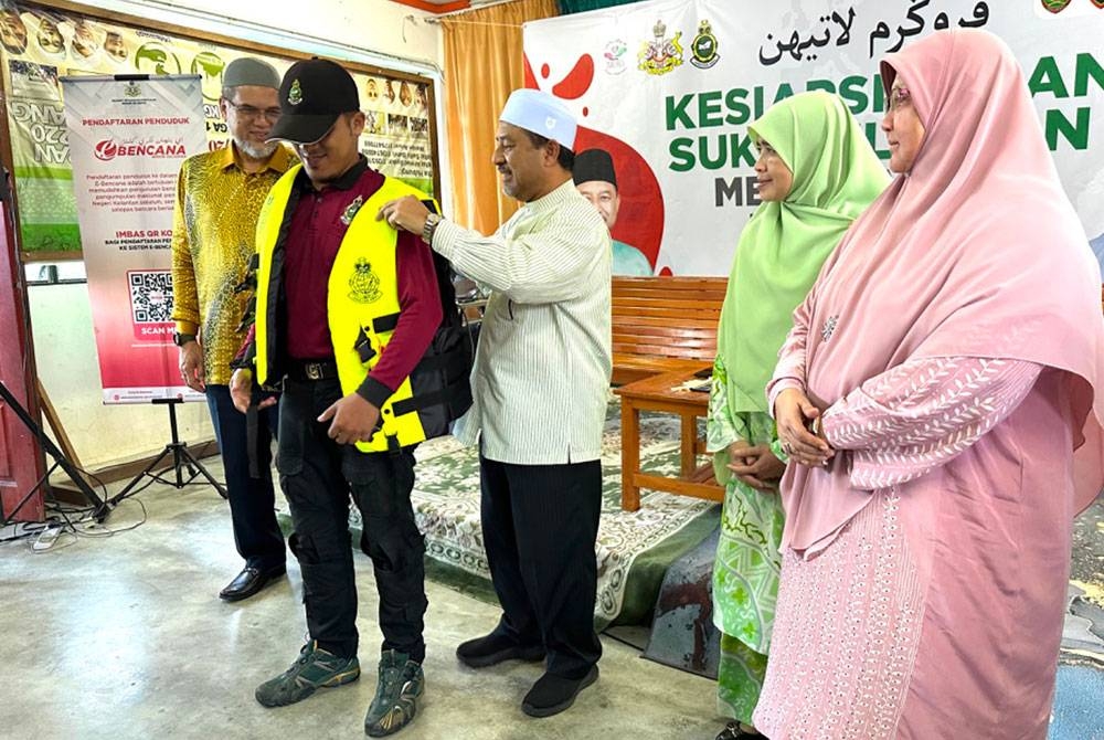 Mohd Nassuruddin (tengah) memakaikan jaket keselamatan kepada wakil peserta Latihah Kesiapsiagaan 200 Sukarelawan Menghadapi Bencana 2023.