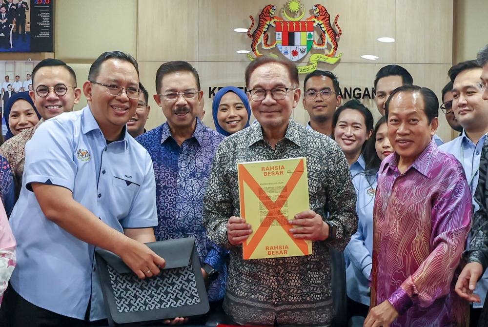 Anwar menunjukkan dokumen ucapan Belanjawan 2024 Malaysia Madani semasa melakukan tinjauan di Kementerian Kewangan hari ini. Foto Bernama