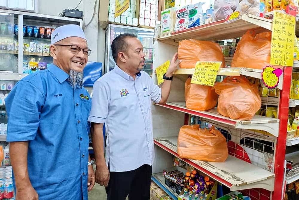 Hairudin (dua dari kiri) melihat barangan runcit yang terdapat di di Pasar Mini Esah Haniff sempena Pelancaran Program Tanpa Tunai@ABR pada Jumaat.