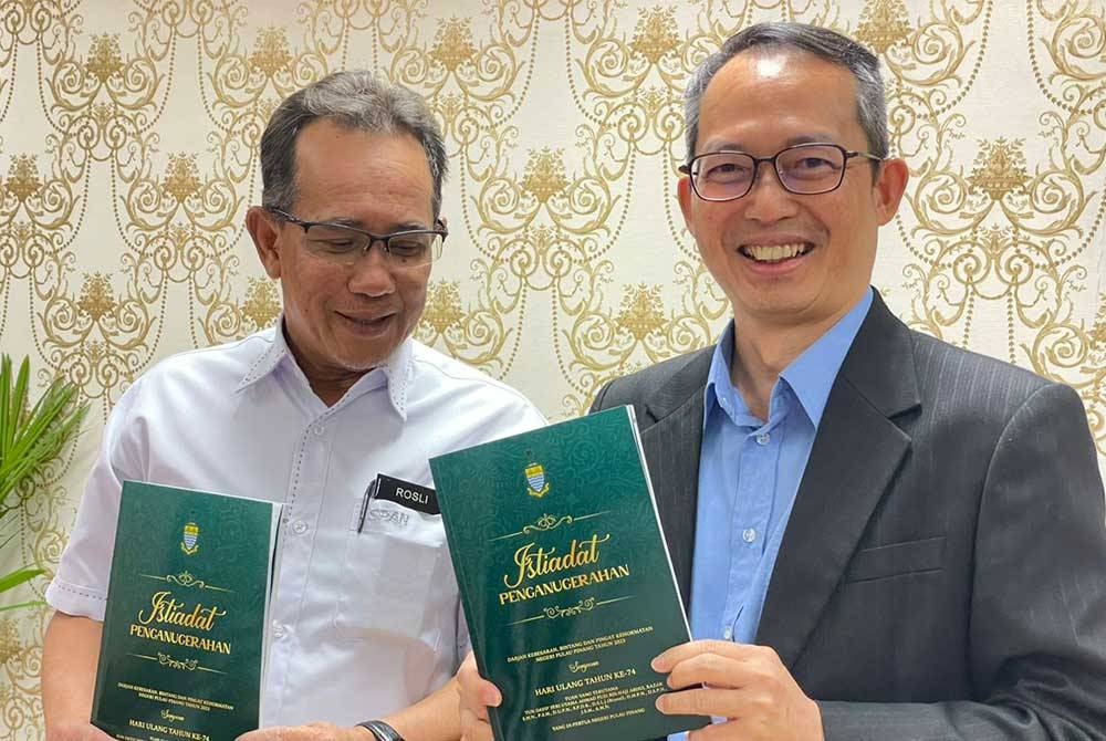 Choo Kiang dan Rosli menunjukkan senarai penerima Darjah Kebesaran Pulau Pinang pada sidang akhbar pada Jumaat.