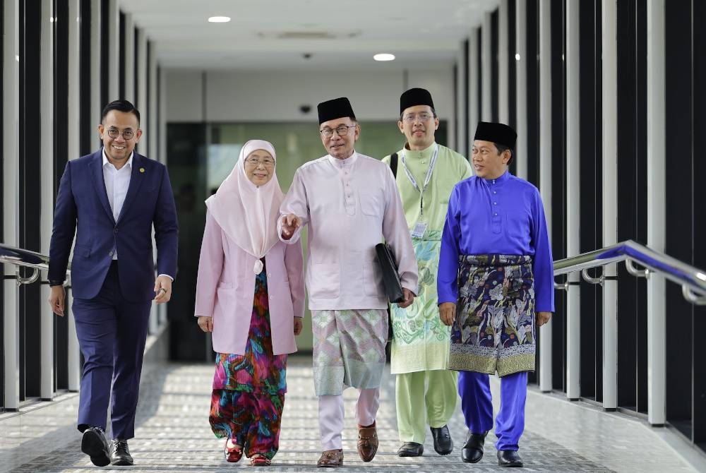 Anwar (tengah) membawa beg dokumen berisi teks ucapan Pembentangan Belanjawan 2024 Malaysia Madani ketika tiba di Bangunan Parlimen hari ini. - Foto Bernama