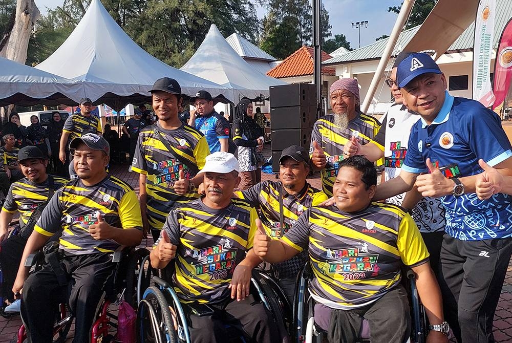 Armizan (kanan) beramah mesra dengan golongan orang kurang upaya pada Perasmian Sambutan Hari Sukan Negara Peringkat Terengganu 2023 di Dataran Pantai Batu Buruk pada Sabtu.