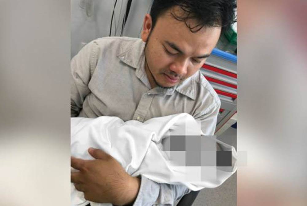 Faizul Ali memangku jenazah anaknya yang disahkan meninggal dunia. - Gambar/ Astro AWANI