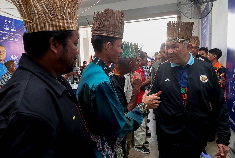 Ahmad Zahid (kanan) bersalaman dengan Tok Batin dan Tok Penghulu sempena perjumpaan dengan Masyarakat Orang Asli Galas di Pusat Khidmat DUN Galas pada Sabtu. - Foto: Bernama