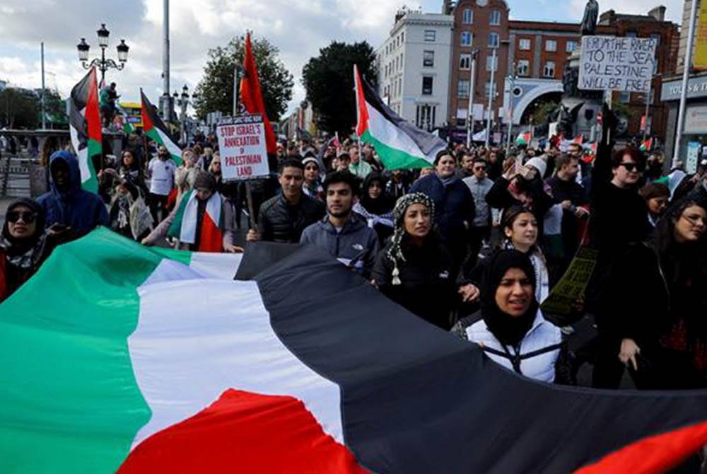 Penunjuk perasaan membawa bendera besar Palestin ketika perhimpunan solidariti bersama Gaza, di Dublin, Ireland. - Foto Reuters