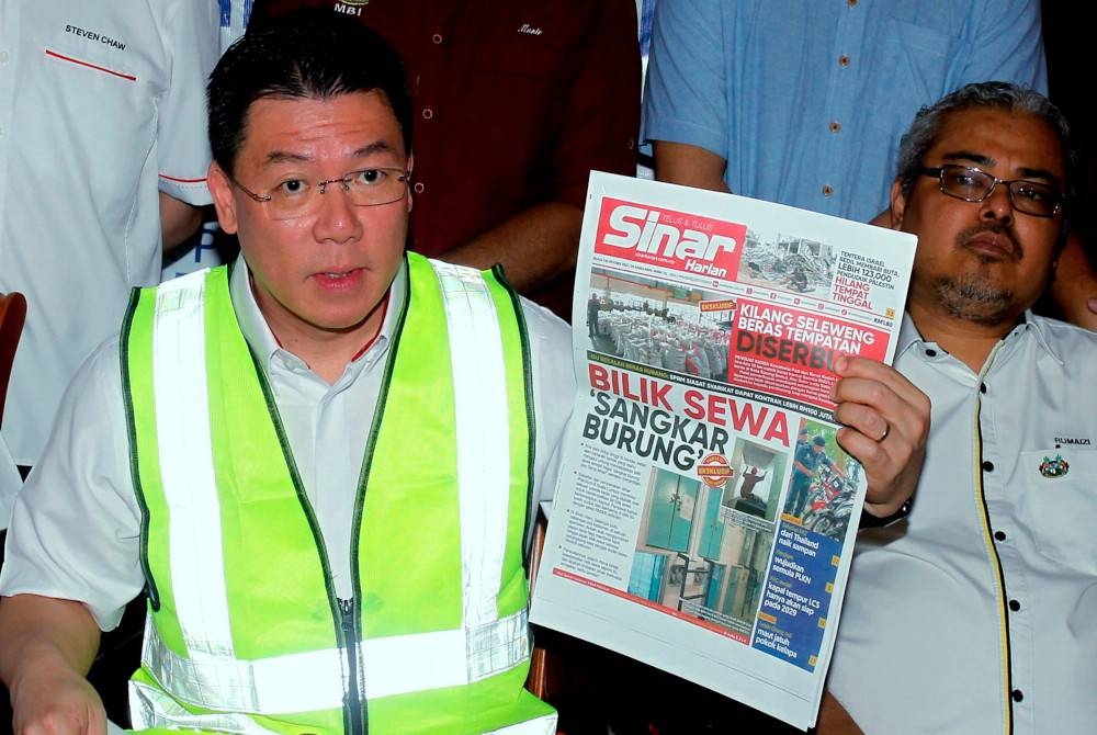 Kor Ming (kiri) menunjukkan akhbar Sinar Harian pada sidang media selepas Majlis Pecah Tanah bagi Projek Pembinaan Pasar Sementara Pasir Pinji di Padang Kilat, Pasir Pinji hari ini. Foto Bernama