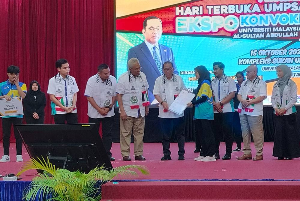 Mohamed Khaled (lima dari kiri) menyerahkan surat tawaran manfaat biasiswa Sulung 2.0 kepada salah seorang penerima sempena Majlis Perasmian Hari Terbuka dan Ekspokonvokesyen UMPSA 2023 di Kompleks Sukan UMPSA Gambang di sini pada Ahad.