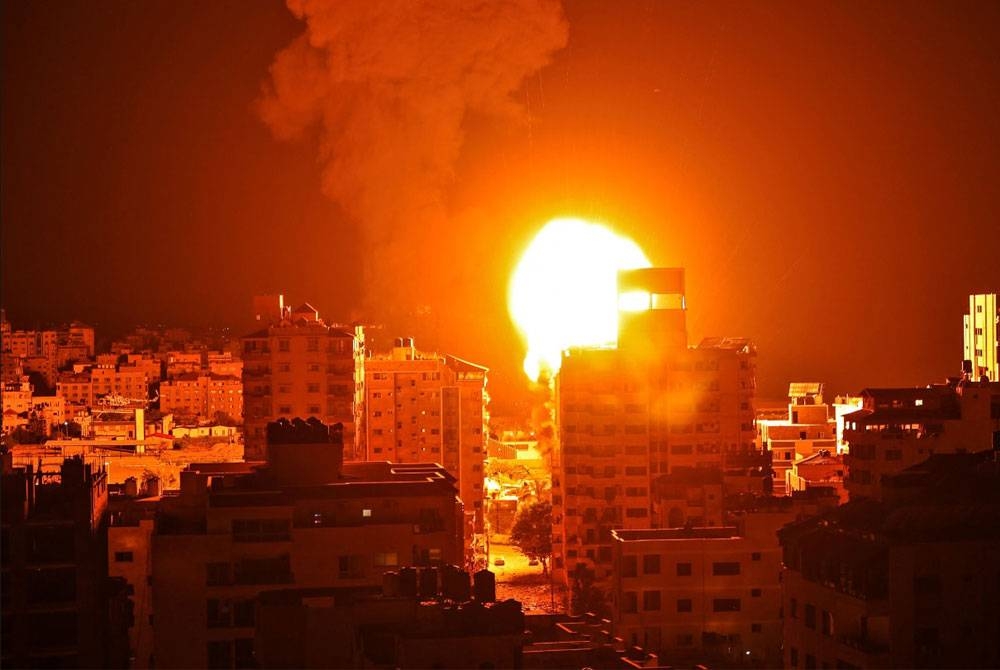 Api daripada letupan roket Israel menerangi kawasan penempatan di Gaza.