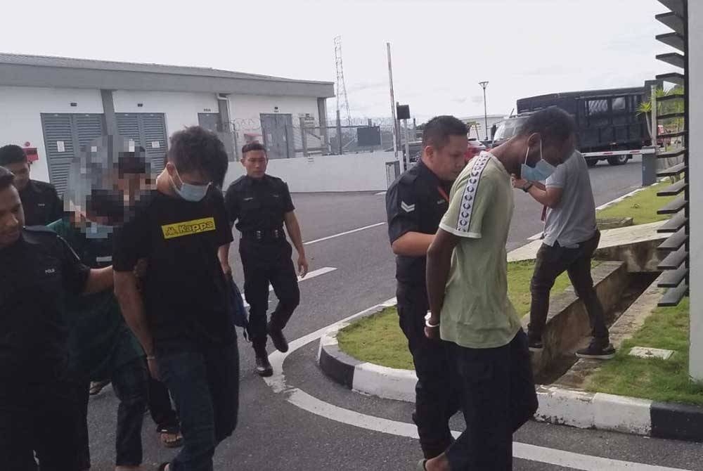 Mohamed Azlan (kanan) dan Fauzan (dua kiri) dibawa ke Mahkamah Majistret pada Isnin. untuk didakwa atas pertuduhan mengedar ganja seberat 20kg.