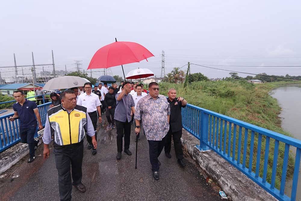 Ab Rauf (dua dari kiri) ketika meninjau keadaan jambatan runtuh di Kampung Setulang Daeng, di Melaka pada Isnin.