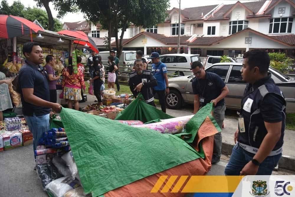 Anggota penguat kuasa melaksanakan operasi di pasar malam di daerah Barat Daya pada Ahad lalu. - Foto MBPP