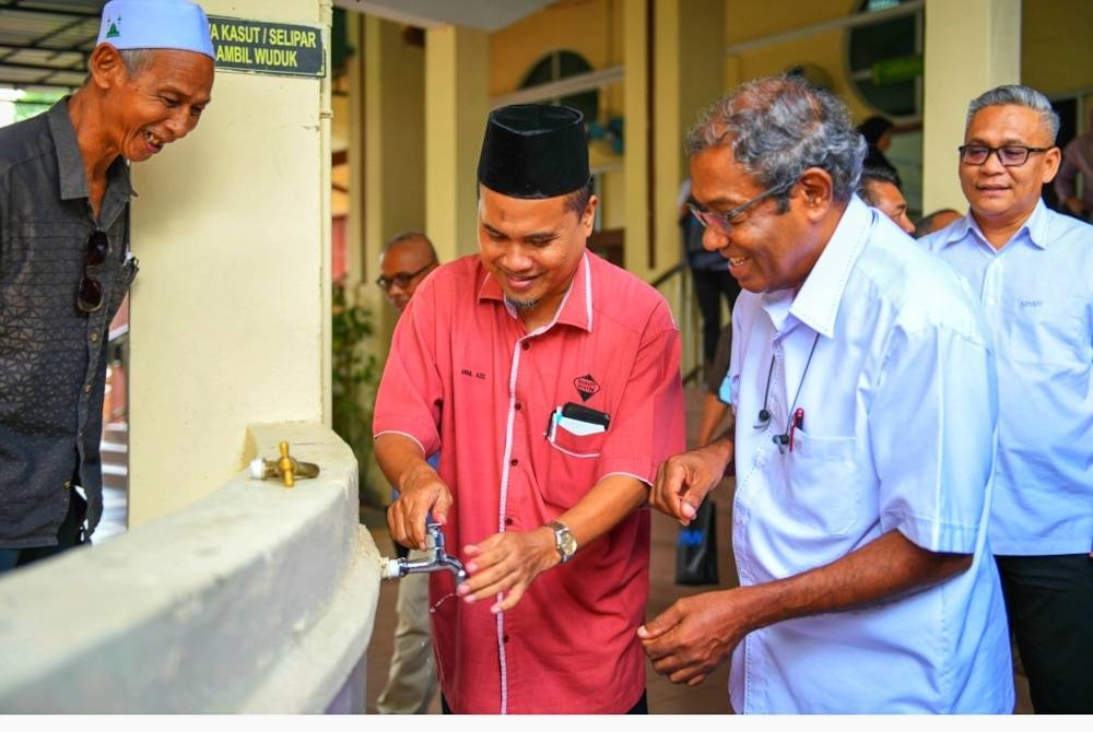 Muhammad Sha'ani (dua dari kanan) bersama Abdul Aziz (dua dari kiri) mencuba pili cekap air yang dipasang di Masjid Abu Bakar, Mentakab pada Isnin. - Foto ihsan SPAN