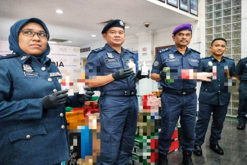 Sazali (dua dari kanan) menunjukkan sebahagian rokok tidak bercukai yang dirampas dalam empat serbuan selepas sidang akhbar di Bangunan Kastam Melaka di Ayer Keroh pada Selasa.