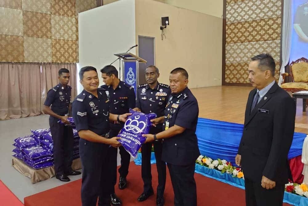 Kamarul Zaman menyampaikan bantuan beras kepada penerima pada Majlis Penyampaian Sumbangan Beras Yayasan Sultan Ibrahim Johor di IPK Johor, Johor Bahru pada Selasa.