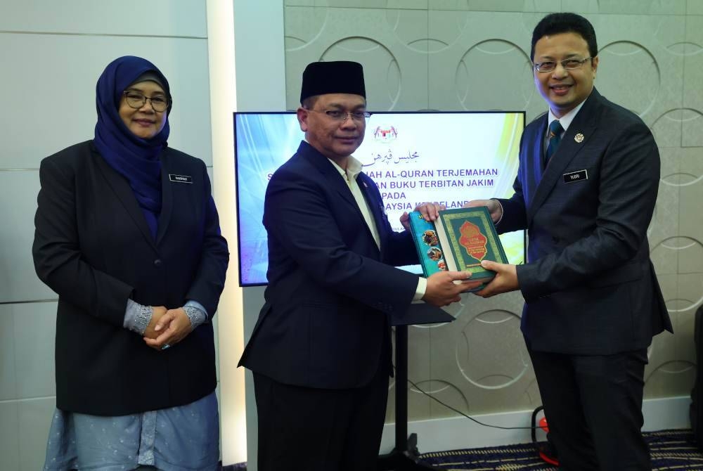 Mohd Na&#039;im (tengah) menyerahkan Naskah Al-Quran kepada Duta Besar Malaysia ke Ireland, Wan Aznainizam Yusri Wan Abdul Rashid (kanan) pada Majlis Penyerahan Sumbangan Naskhah Al-Quran Terjemahan Bahasa Inggeris dan Buku Terbitan JAKIM di Kompleks Islam Putrajaya (JAKIM), pada Selasa. - Foto Bernama