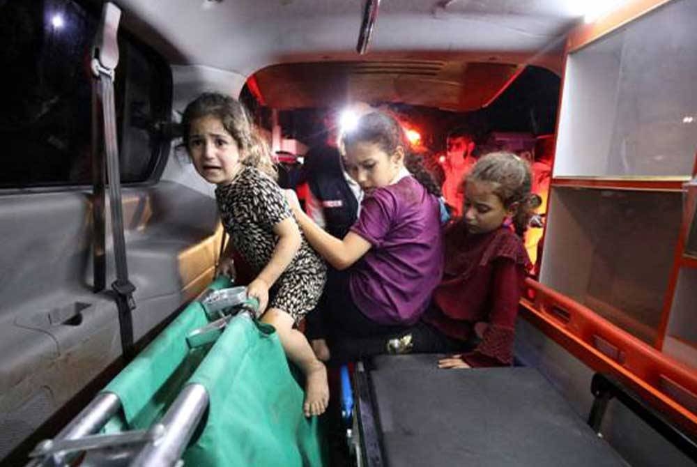 Kanak-kanak berlindung di dalam sebuah ambulans di Hospital Shifa susulan serangan udara tentera rejim Zionis Israel ke atas Hospital Al-Ahli al-Arabi di Gaza. - Foto Reuters