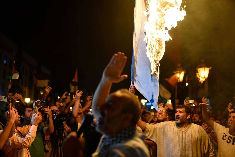 Penunjuk perasaan membakar bendera Israel di Rabat, Maghribi susulan lebih 500 orang terbunuh dalam serangan udara Israel ke atas Hospital Al-Ahli Baptist. - Foto EPA