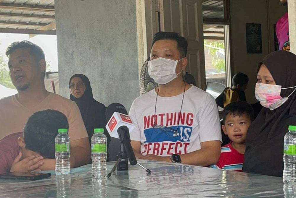 Muhammad Hasmalizam (tengah) bersama isteri Allahyarham Muhammad Izzat, Nurul Diyana ditemui pemberita di rumah mangsa di Kampung Peramu pada Rabu.