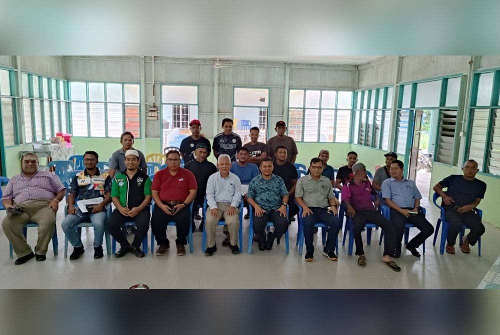 Hamdan (lima dari kiri) dan Mohd Hafiz (lima dari kanan) ketika pertemuan bersama bekas pekerja Ladang Air Putih di Balai Raya Kampung Teladas, di Kemaman pada Rabu.