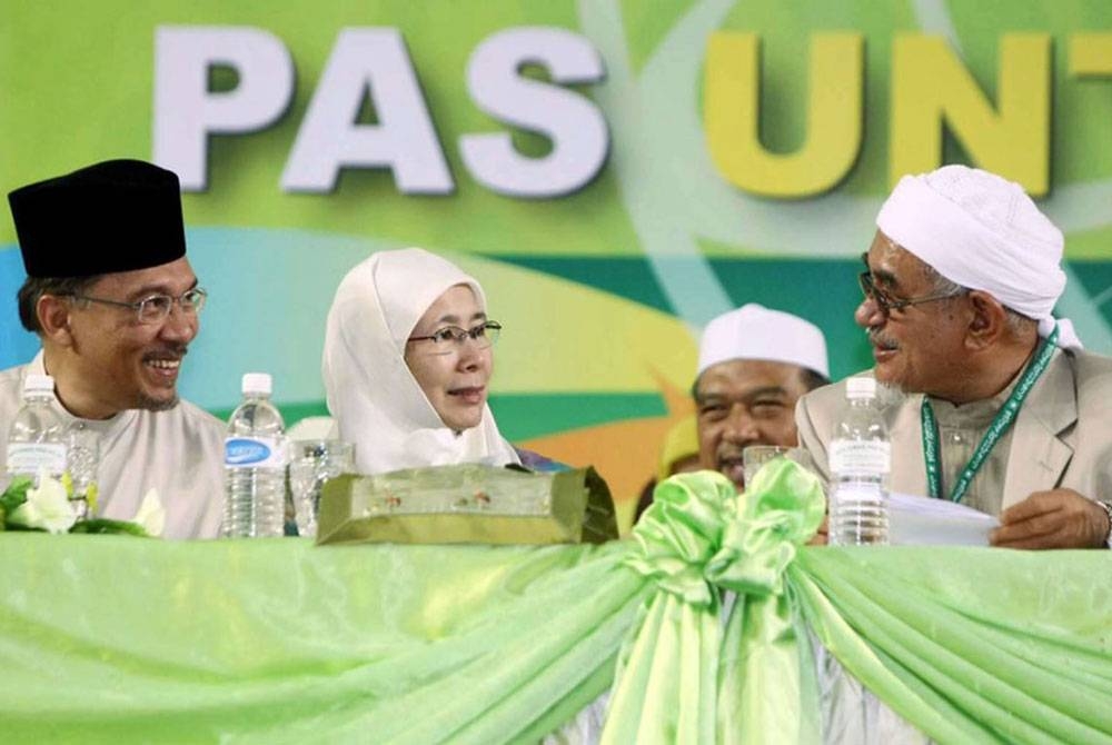 Presiden Pas, Datuk Seri Abdul Hadi Awang (kanan) bersama Anwar dan isterinya, Datin Seri Wan Azizah Wan Ismail semasa majlis perasmian Muktamar Tahunan Pas ke-54 di Stadium Indera Mulia. - Foto fail Bernama