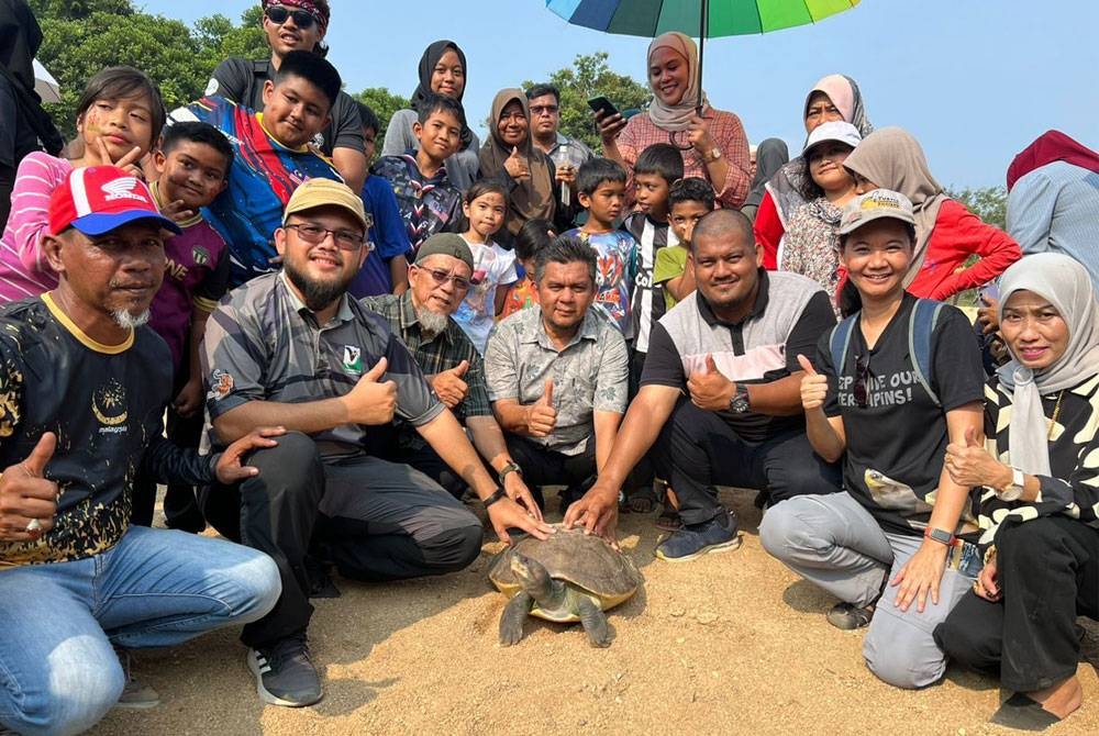 Ahli Dewan Undangan Negeri Air Putih Kemaman, Mohd Hafiz Adam (empat dari kiri) dan Pelf Nyok (dua dari kanan) melepas tuntung ke Sungai Kemaman di Kampung Pasir Gajah.