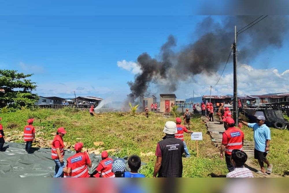 Ahli Pasukan Bomba Komuniti Atas Air Kampung Tanjung Aru melakukan demonstrasi memadamkan kebakaran sempena Majlis Pentauliahan Pasukan Bomba Komuniti Peringkat Zon Kota Kinabalu di Kampung Tanjung Aru, Kota Kinabalu.